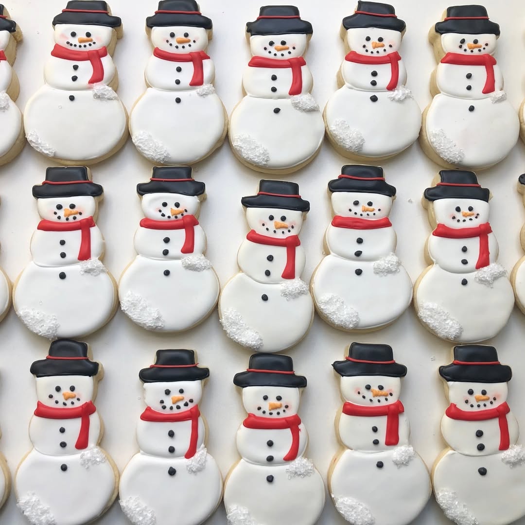 Classic snowman cookies with red scarves and black hats in rows